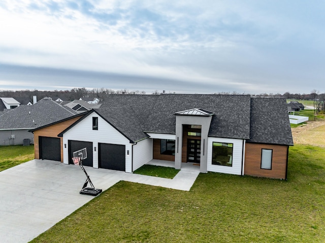 view of front of house featuring central air condition unit, a front lawn, and a garage