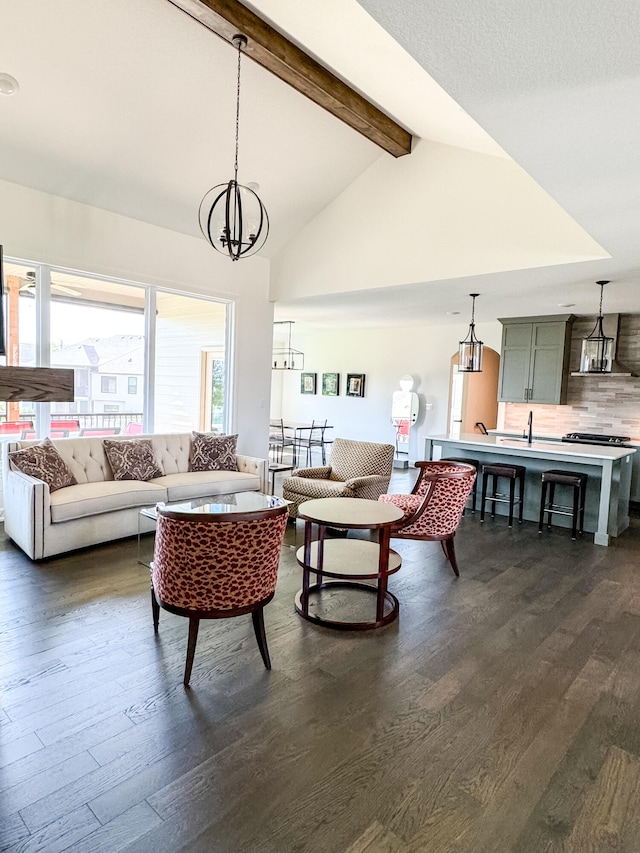 living room featuring vaulted ceiling with beams, dark hardwood / wood-style floors, and an inviting chandelier