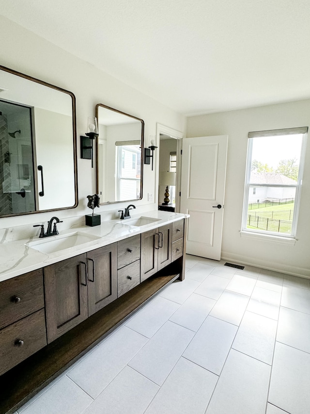 bathroom with tile patterned floors, vanity, and walk in shower