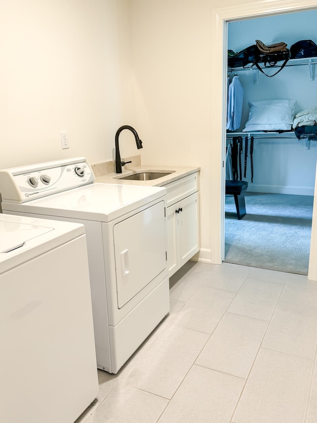 laundry area with cabinets, independent washer and dryer, sink, and light tile patterned floors