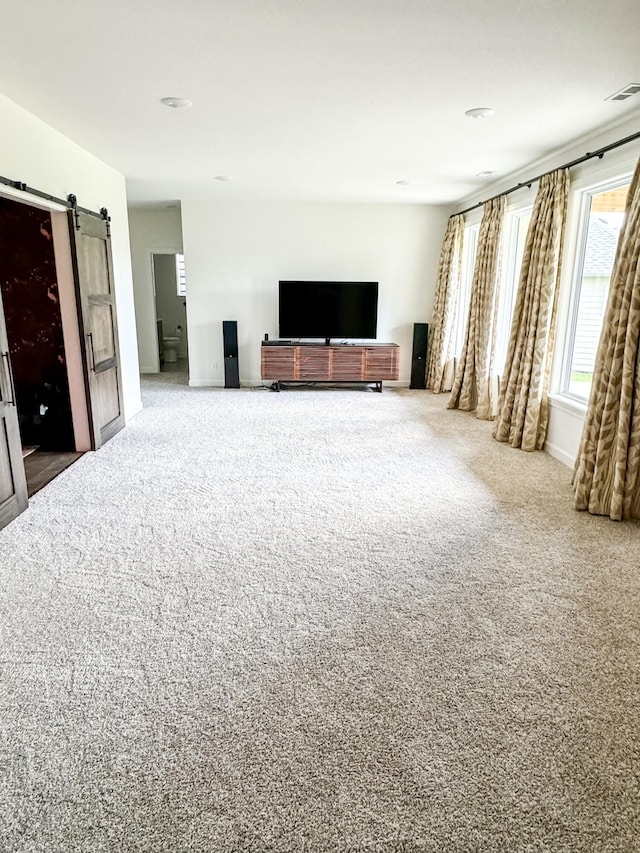 living room featuring a barn door and carpet floors