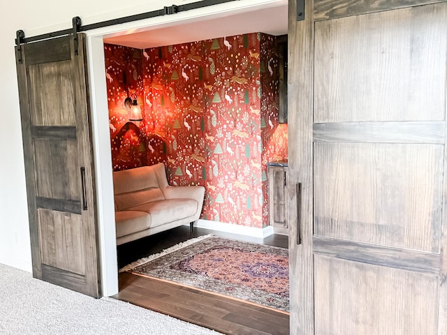 living area with wood-type flooring and a barn door