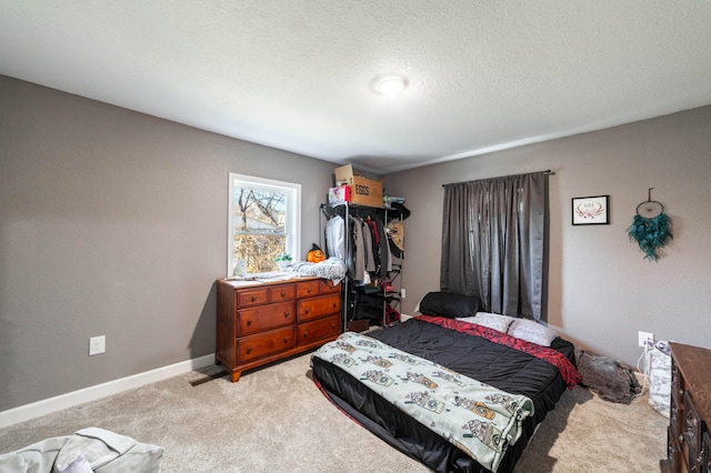 bedroom featuring light carpet and a textured ceiling