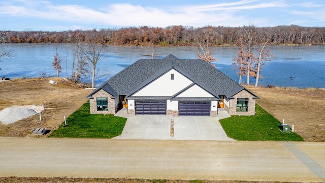 view of front of house featuring a front yard, a water view, and a garage