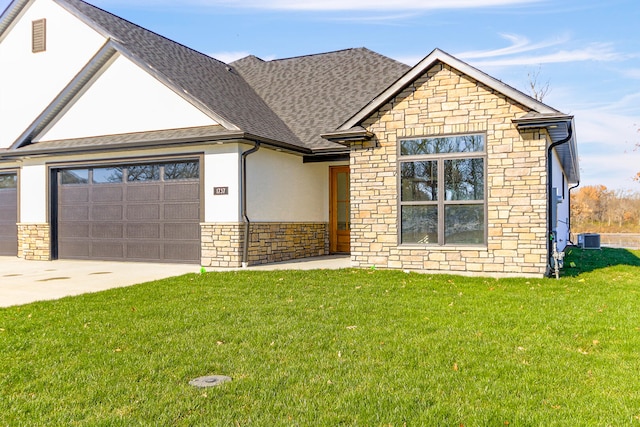 view of front of house featuring cooling unit, a garage, and a front yard