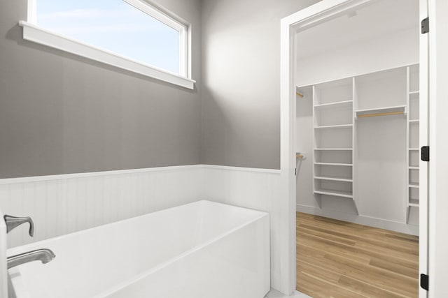 bathroom with hardwood / wood-style floors and a tub