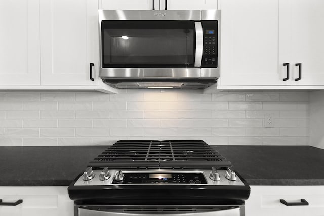 kitchen with appliances with stainless steel finishes, backsplash, and white cabinetry