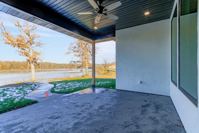 view of patio with ceiling fan and a water view