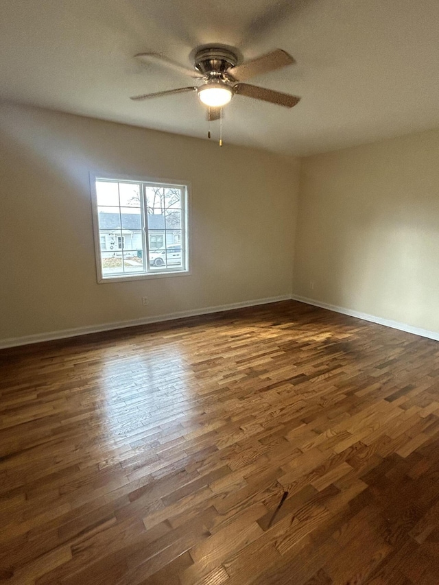 spare room featuring ceiling fan and dark wood-type flooring