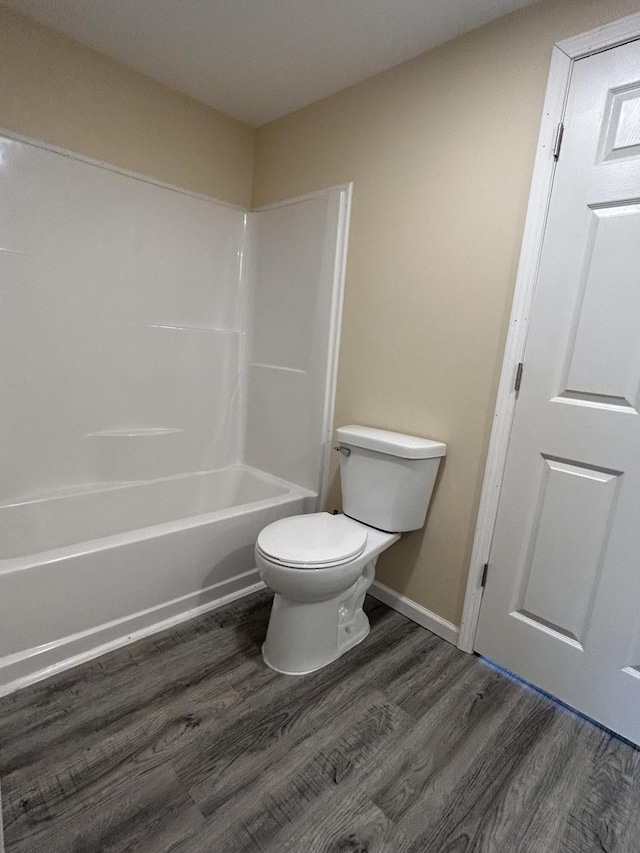 bathroom with wood-type flooring, toilet, and shower / tub combination