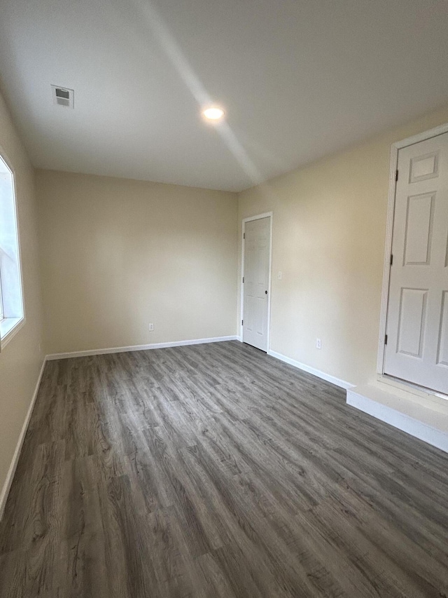 unfurnished room with dark hardwood / wood-style flooring