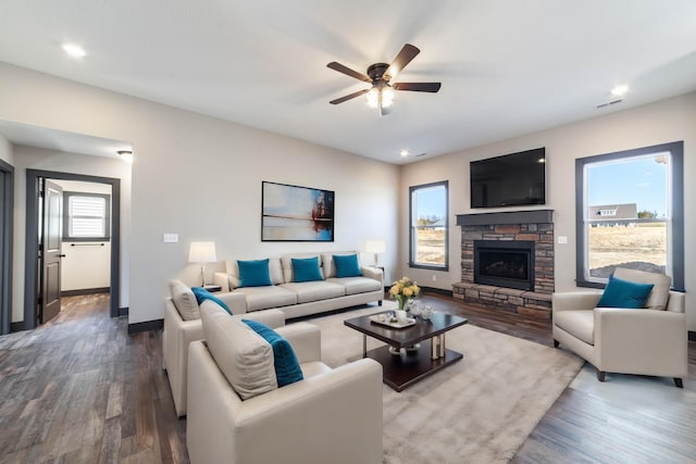 living room with a stone fireplace, ceiling fan, and hardwood / wood-style floors