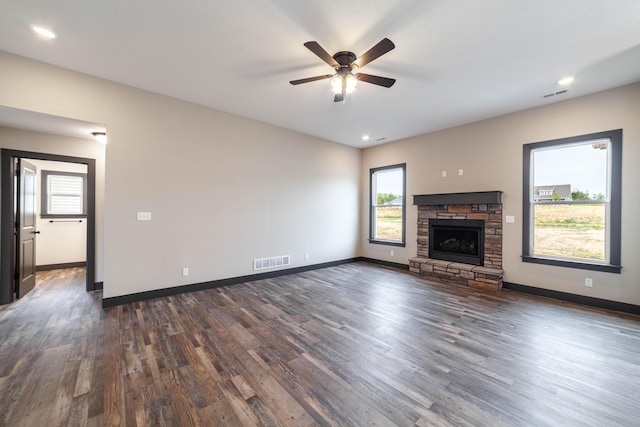 unfurnished living room with a fireplace, ceiling fan, and dark wood-type flooring