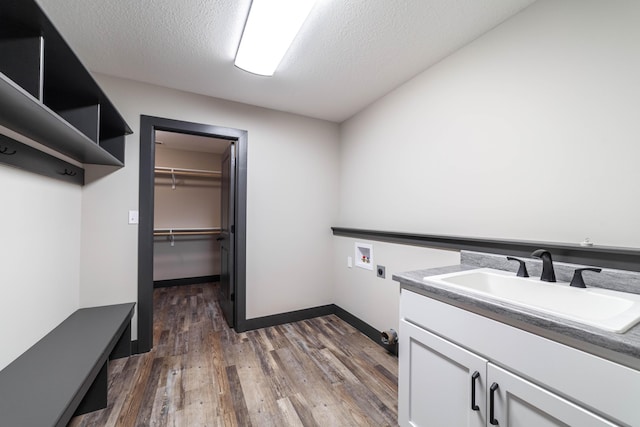 clothes washing area featuring sink, dark wood-type flooring, washer hookup, hookup for an electric dryer, and a textured ceiling