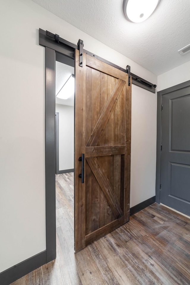 details with a barn door and wood-type flooring