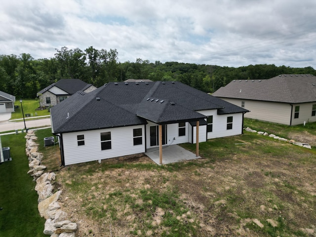 back of property featuring a lawn, cooling unit, and a patio area