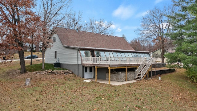 back of house featuring a deck, central AC unit, and a lawn