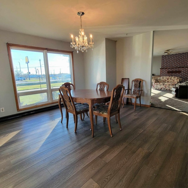 dining area with dark wood-type flooring and a notable chandelier