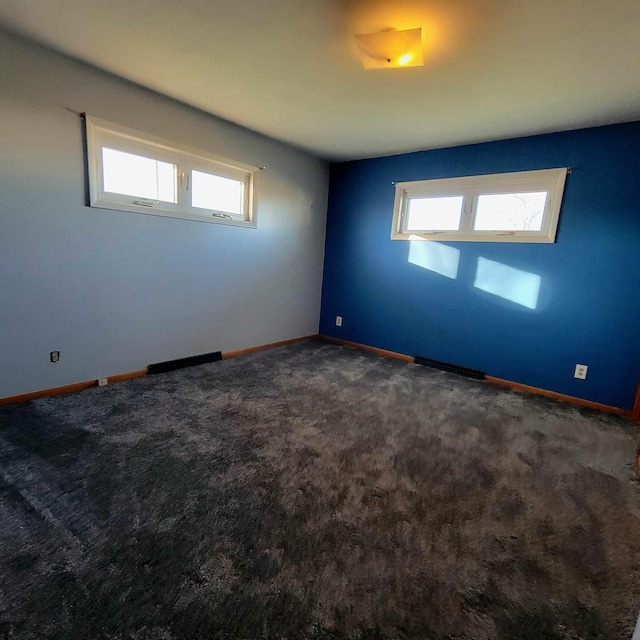 carpeted spare room featuring plenty of natural light