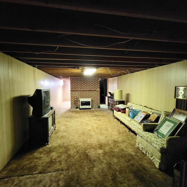 basement featuring a fireplace, carpet flooring, heating unit, and wooden walls