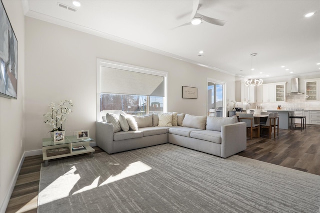 living room featuring ceiling fan, crown molding, and dark wood-type flooring