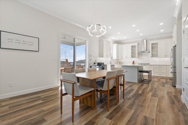 dining space with ornamental molding, dark hardwood / wood-style floors, and an inviting chandelier