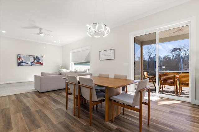 dining space featuring ceiling fan with notable chandelier, dark hardwood / wood-style floors, and ornamental molding