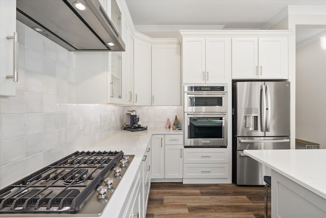 kitchen with white cabinetry, dark hardwood / wood-style floors, wall chimney range hood, and appliances with stainless steel finishes