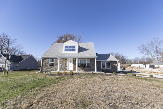 cape cod house featuring a front yard