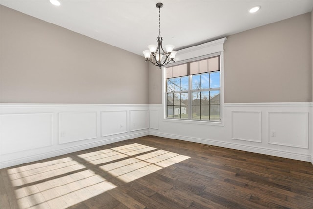 unfurnished room with dark hardwood / wood-style flooring and an inviting chandelier