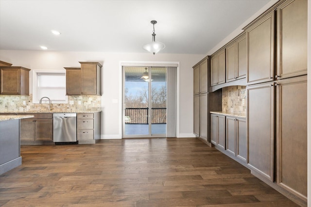 kitchen with decorative backsplash, stainless steel dishwasher, light stone countertops, and dark wood-type flooring