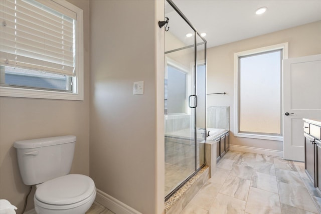 bathroom with a shower with door, vanity, and toilet