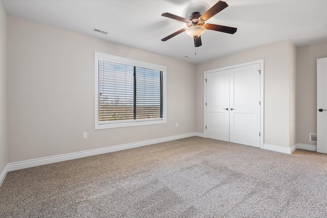 unfurnished bedroom with carpet flooring, a closet, and ceiling fan