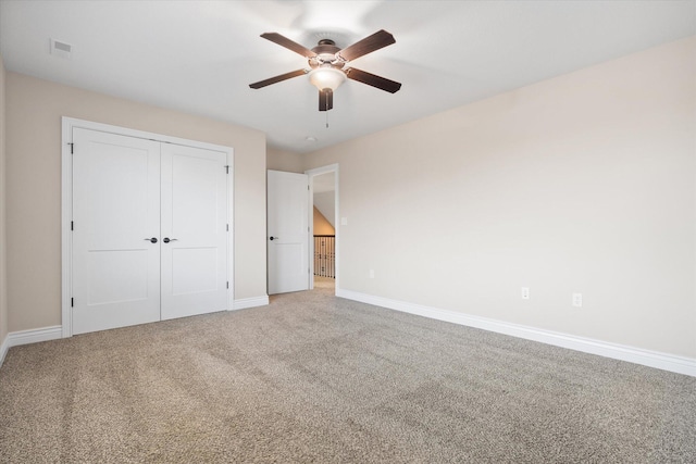 unfurnished bedroom with carpet, ceiling fan, and a closet