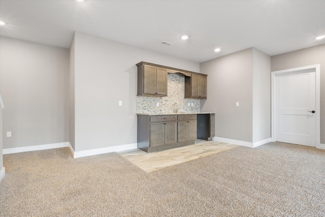 kitchen with sink, light carpet, and tasteful backsplash