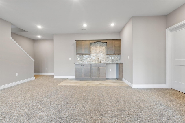 unfurnished living room with sink and light carpet