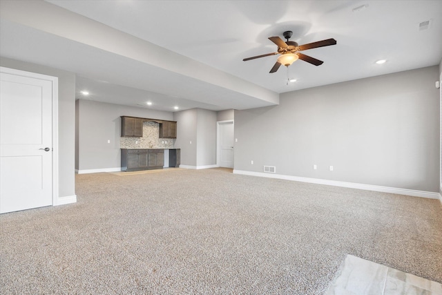 unfurnished living room featuring ceiling fan and light carpet