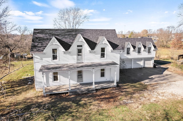 exterior space with covered porch, a garage, and a front lawn