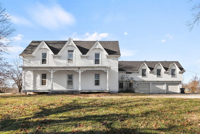 victorian home with a front lawn, a porch, and a garage