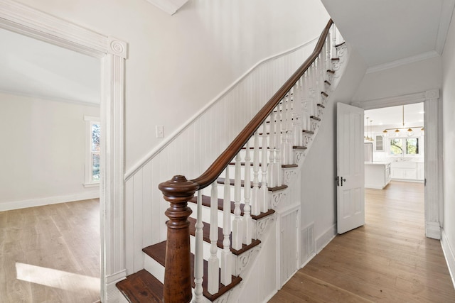 stairs featuring hardwood / wood-style floors and crown molding