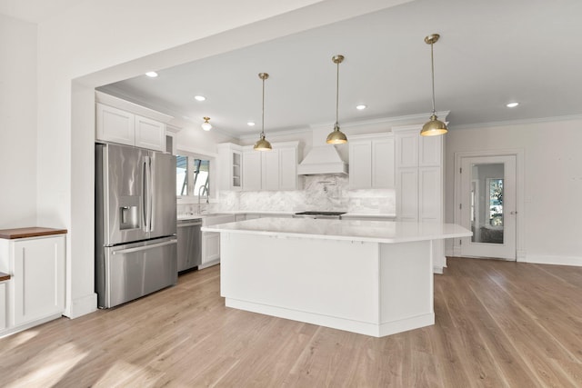 kitchen featuring light hardwood / wood-style floors, a healthy amount of sunlight, stainless steel appliances, and custom exhaust hood