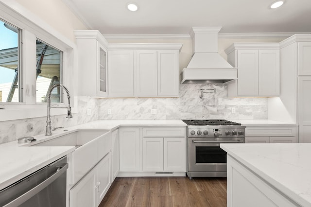 kitchen featuring white cabinetry, stainless steel appliances, dark hardwood / wood-style flooring, custom range hood, and ornamental molding