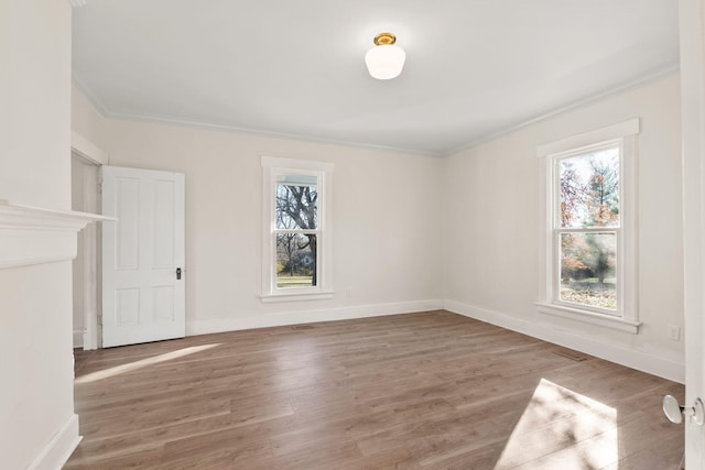 spare room with hardwood / wood-style flooring, plenty of natural light, and ornamental molding