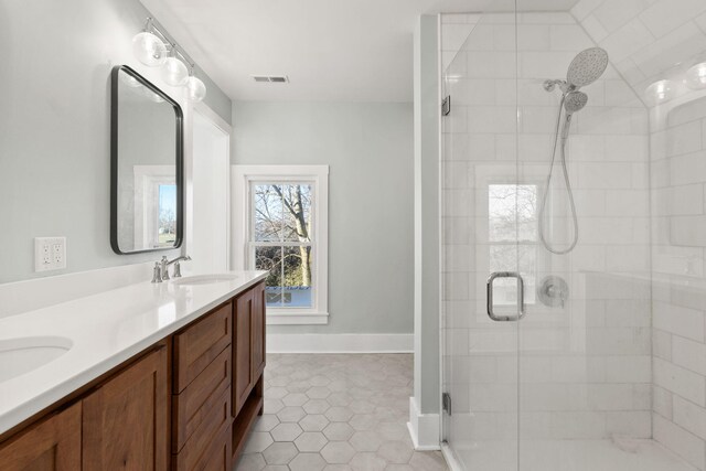 bathroom with tile patterned flooring, vanity, and a shower with door