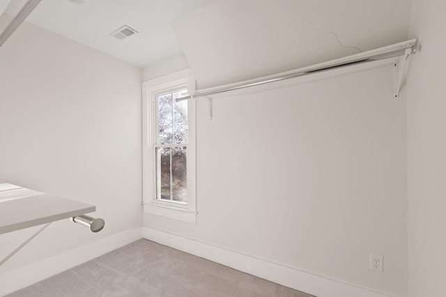 spacious closet featuring light colored carpet