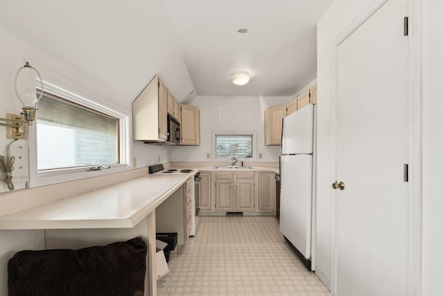 kitchen with light brown cabinets, white fridge, and stainless steel electric range oven