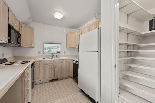 kitchen with light brown cabinets, sink, vaulted ceiling, and black appliances