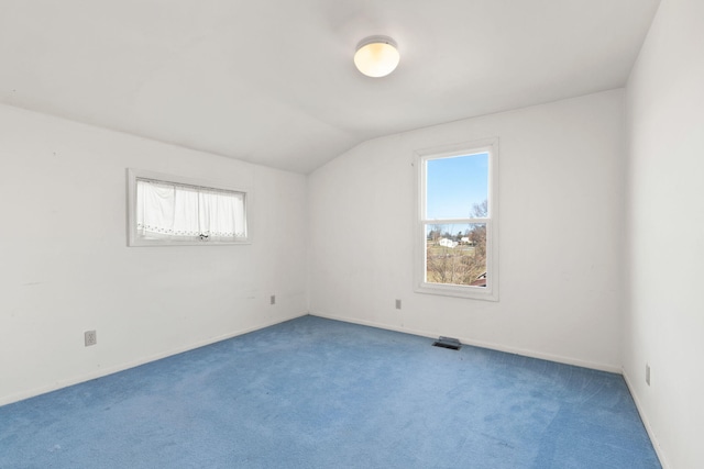 empty room featuring carpet and lofted ceiling