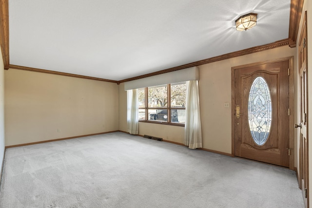 carpeted entryway featuring ornamental molding