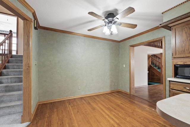 unfurnished living room with ceiling fan, light hardwood / wood-style floors, and ornamental molding